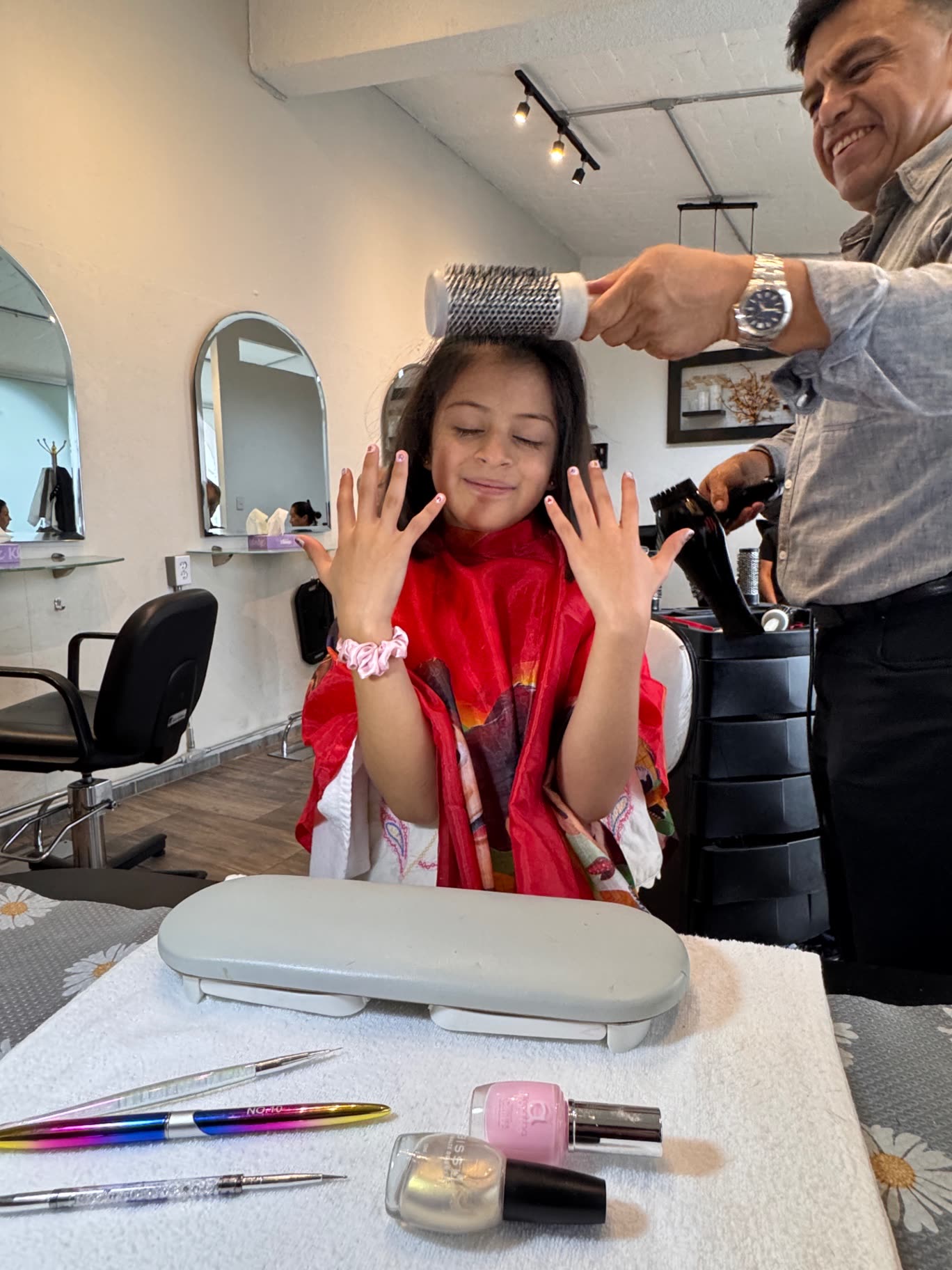 Cliente pequeña mostrando su manicure recién hecho