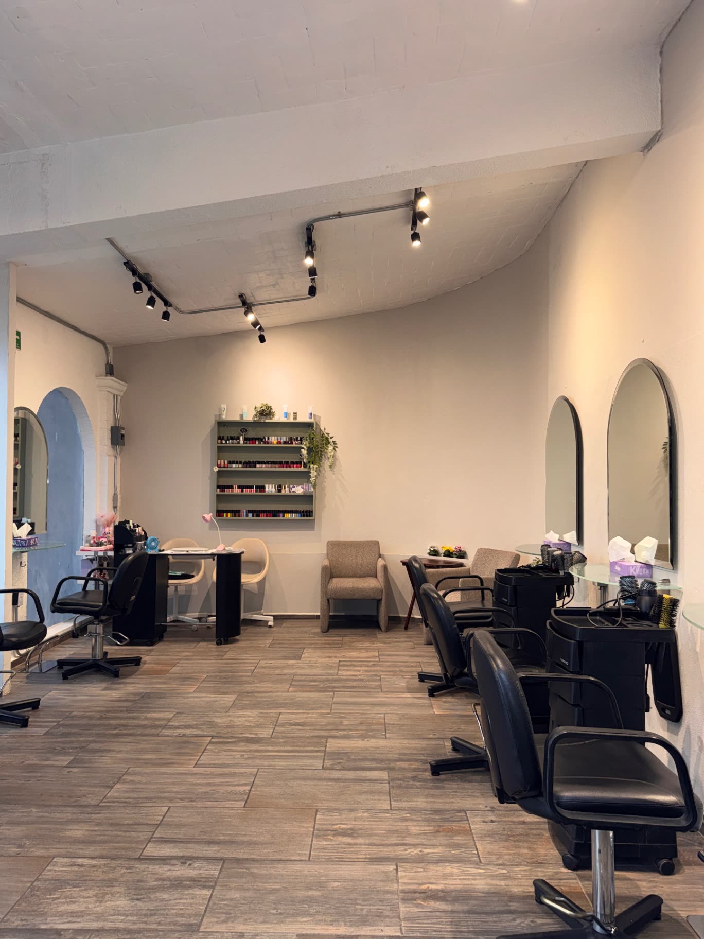 Interior del salón con espejos de arco y estación de esmaltes